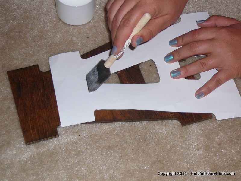 applying modpodge to the back of the horse stall sign letter