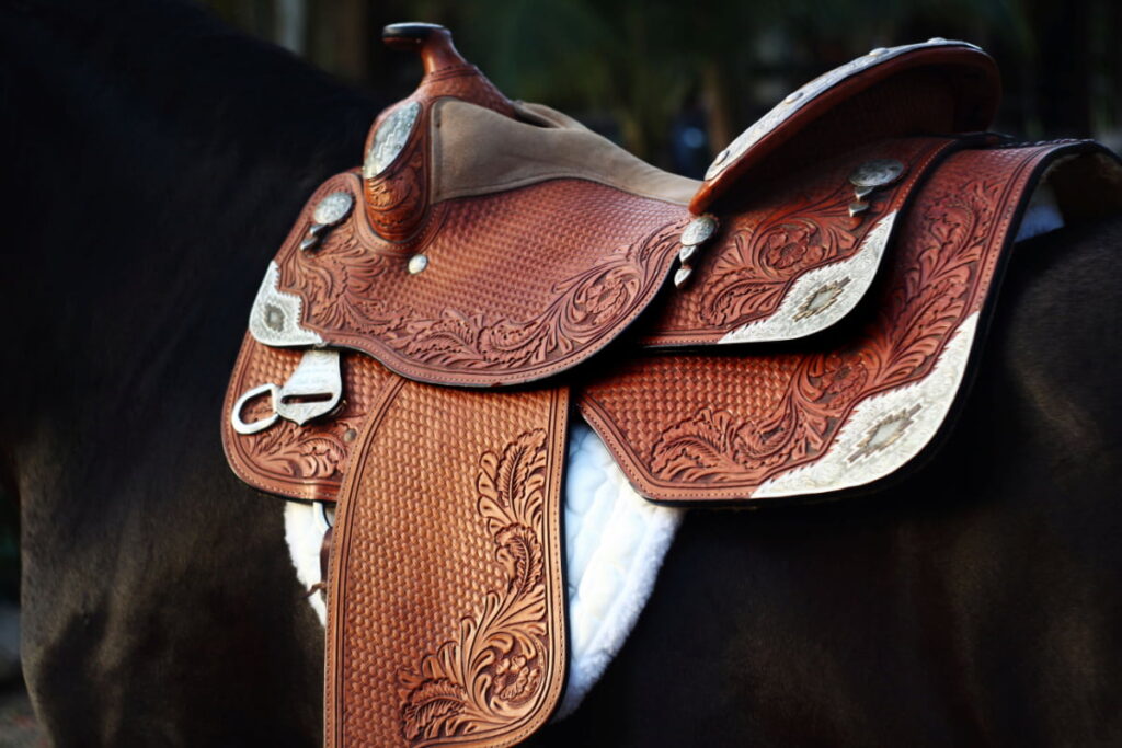 A brown show saddle on a black horse