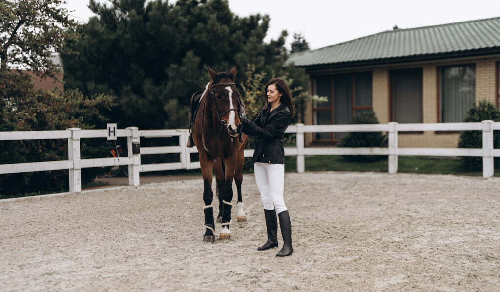 a woman and a horse preparing for a race, Equestrian competition concept