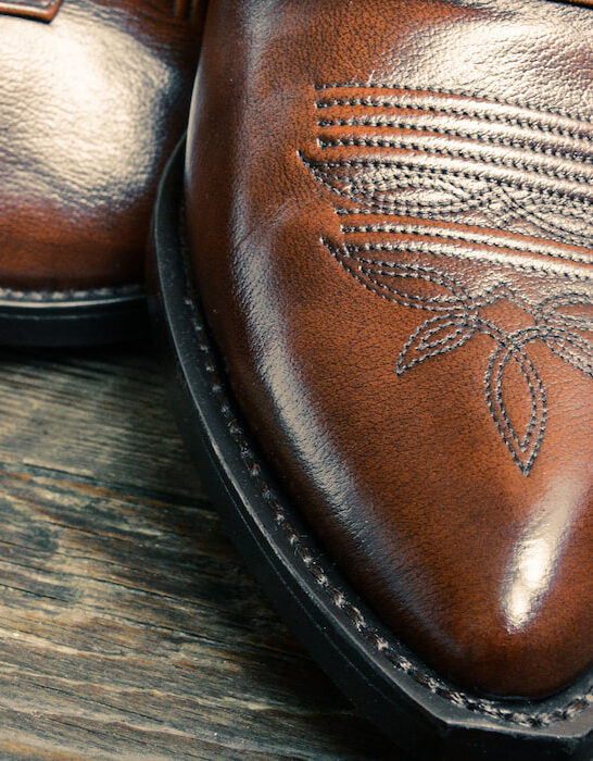 leather cowboy shoes on wooden table