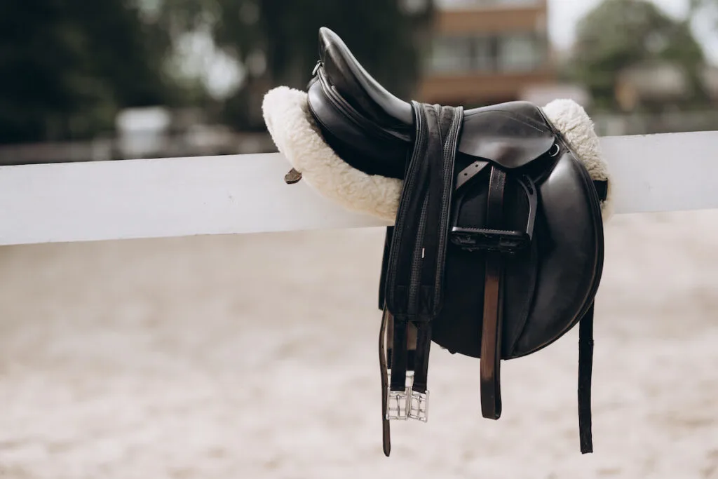 English saddle hanging on a wooden stable door