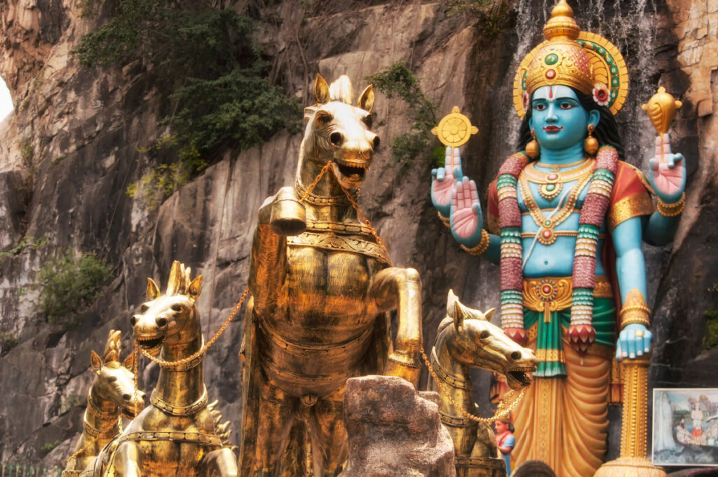 Four golden horse statue of Lord Krishna in front of a cave