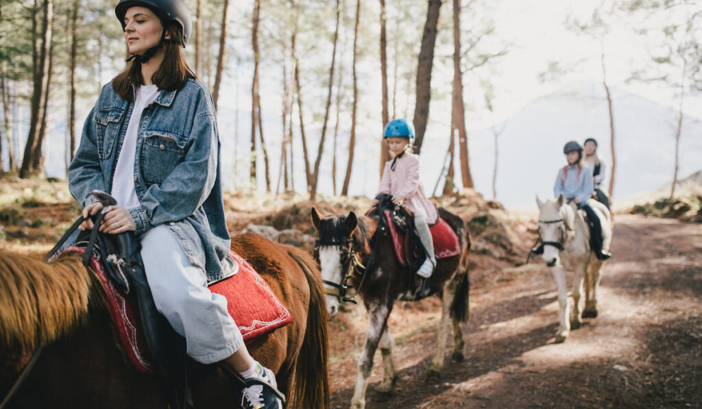 Group of people walking on horseback through picturesque places