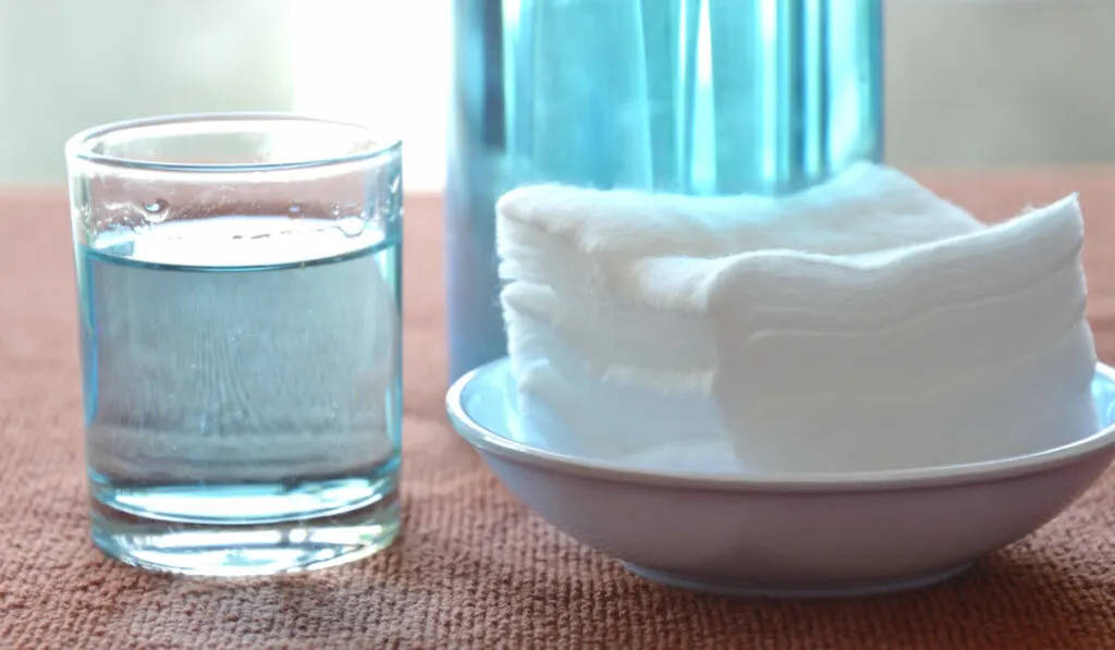 Hydrogen peroxide in glass and white cotton on a plate on the table 