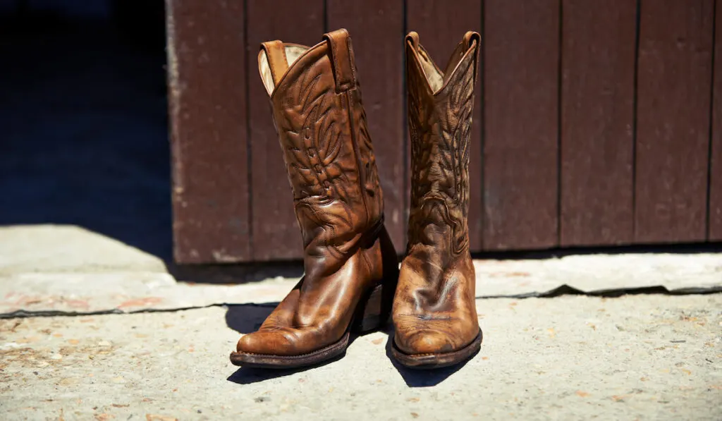 Pair of cowboy boots outside barn