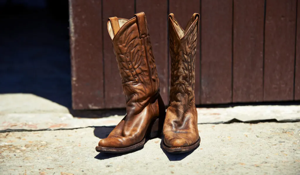 Ready to wear shot of pair of cowboy boots outside a barn