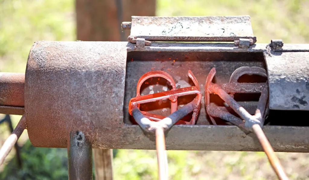 Two branding irons heating in a burner