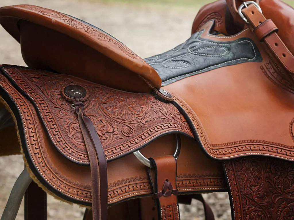 Western Saddle Close-up hanging from wooden fence