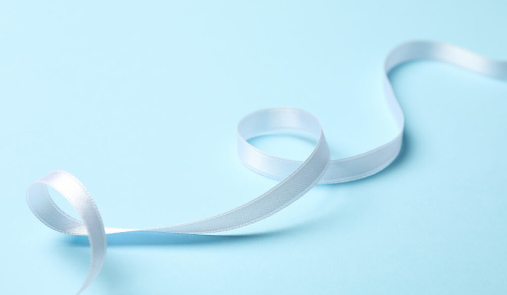 White curly ribbon on light blue background
