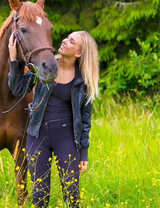 Young-woman-with-her-arabian-horse-standing-in-the-field-ee220326