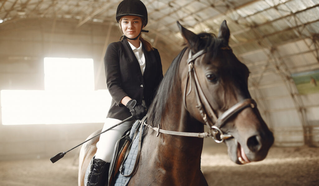 a young equestrian rider with her horse training