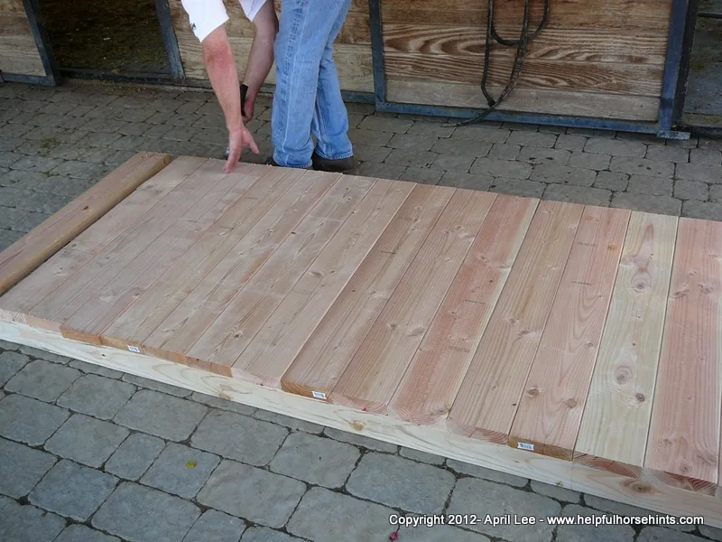 Man checking his almost done diy horse obstacle bridge  