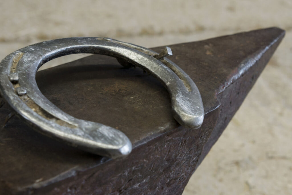 an iron horse shoe on top of an anvil 