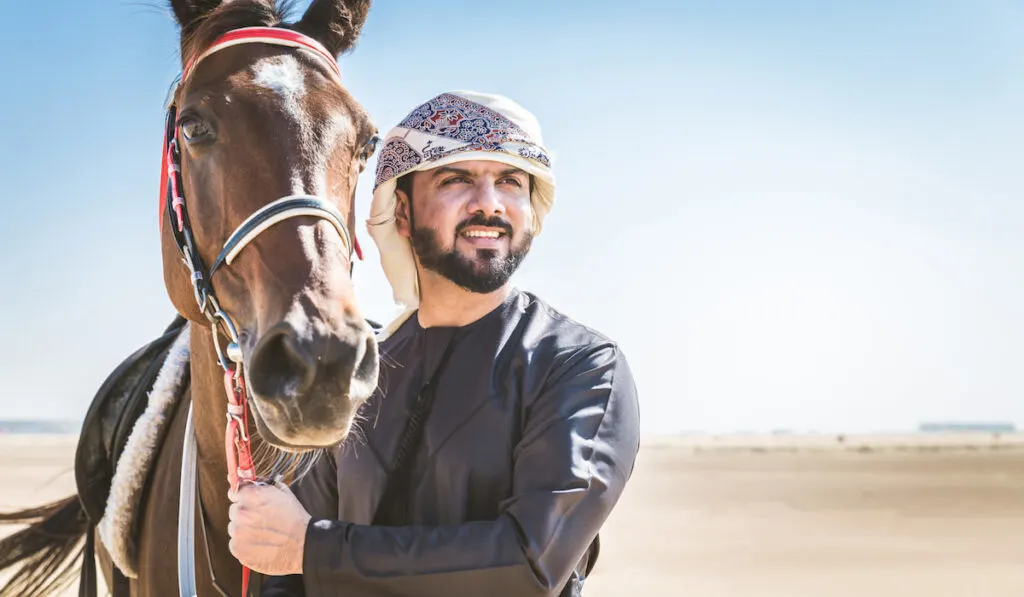 arabian man and arabian horse in the desert 