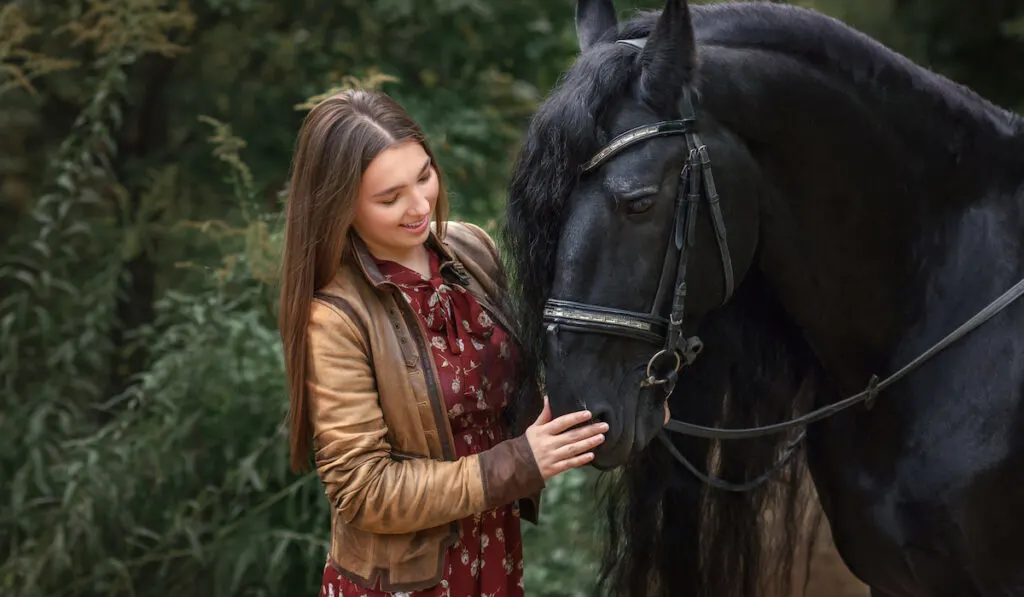 beautiful girl with friesian horse