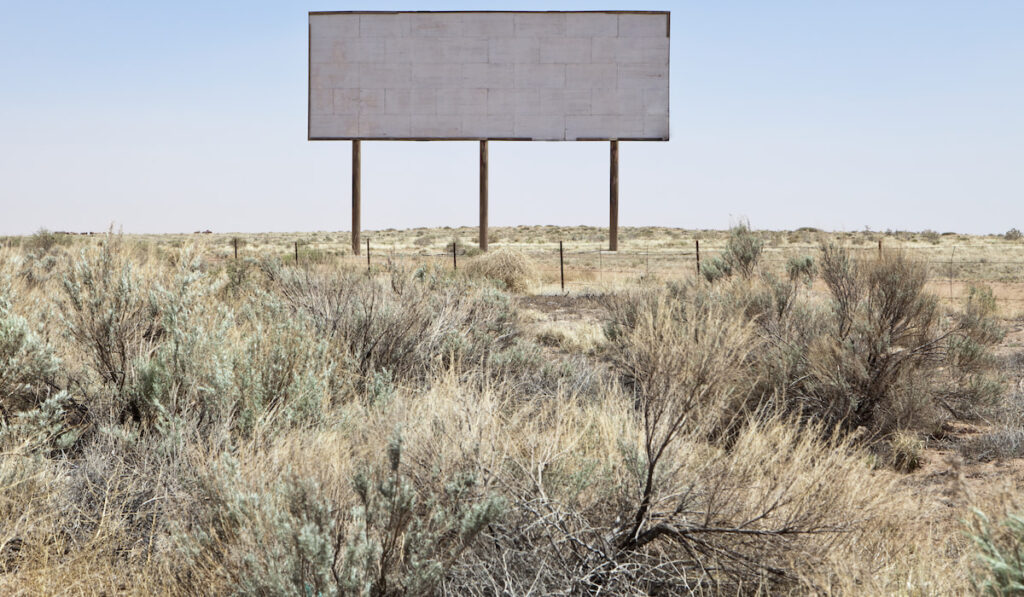 blank dessert billboard and Sagebrush in the dessert field