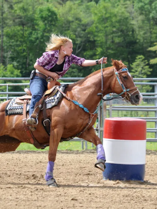 Young adult woman galloping around a turn in a barrel race - ss230506