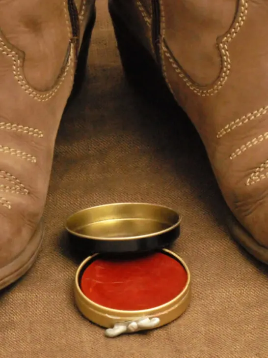 dirty looking cowboy boots with a red colored conditioner