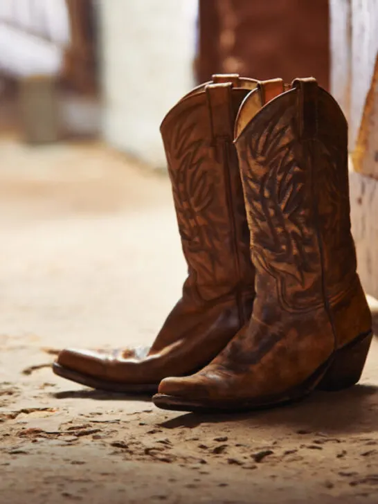 pair of cowboy boots at the door of a barn