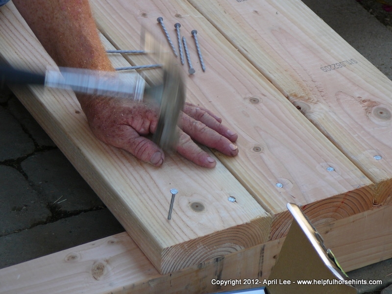 hammering nails into wood for diy horse bridge