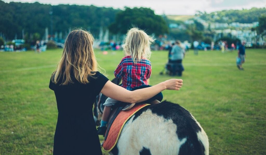 little girl riding a donkey