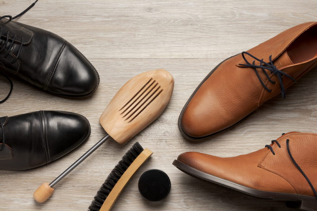 men's shoes and boots with a shoe tree and a brush