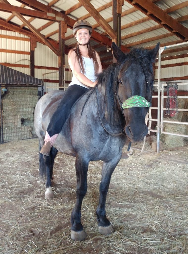 Woman riding a horse in the barn