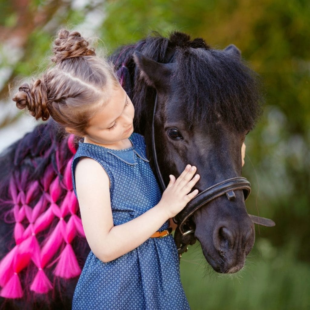 Little girl petting a pony