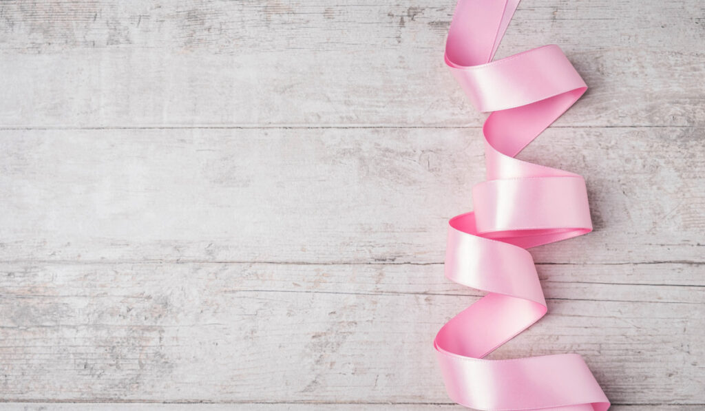 pink ribbon on wooden table