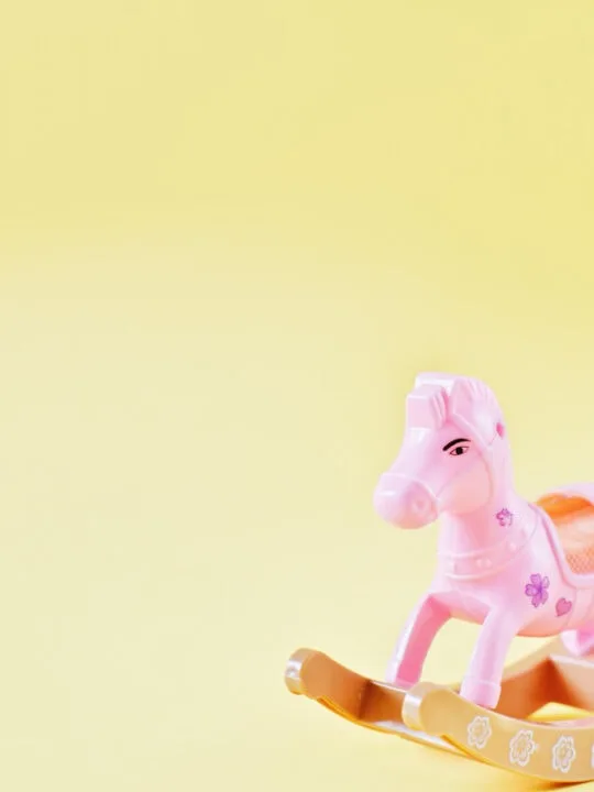 pink rocking horse toy on yellow background