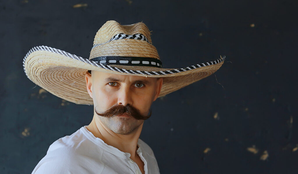 male mexican with mustache wearing a cowboy hat