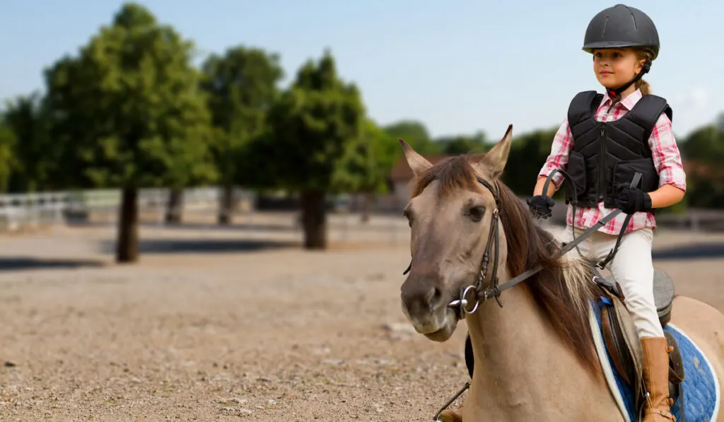 young girl training to ride a horse