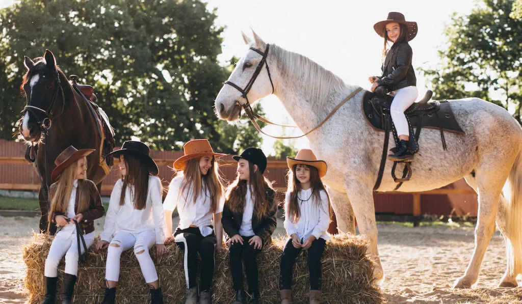 young kids learning to ride a horse